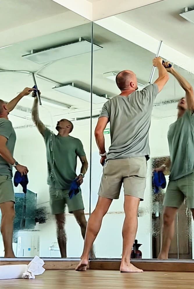 Qtana cleaner using a squeegee on large glass windows